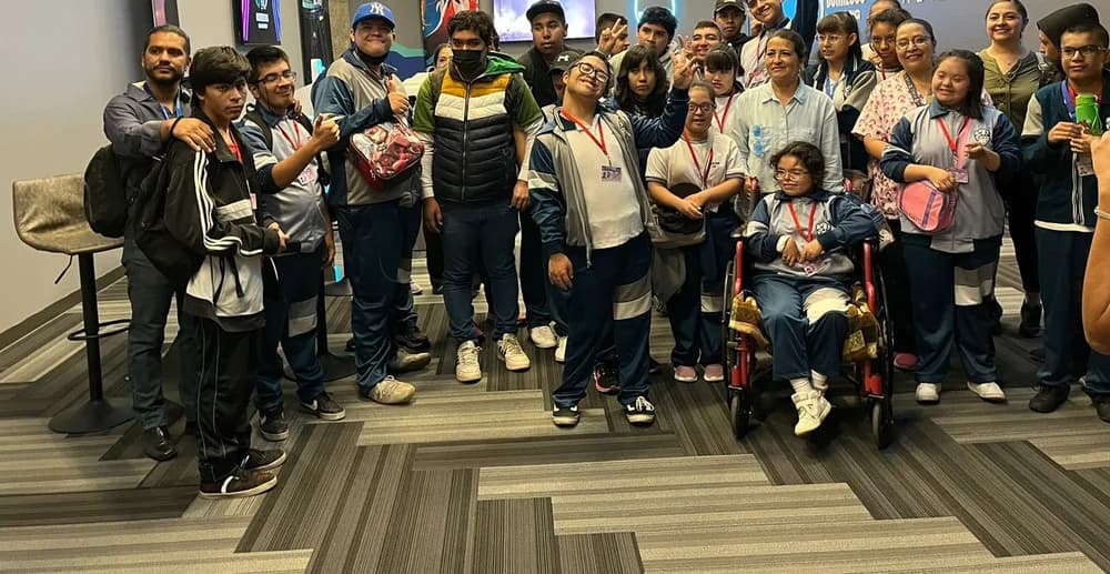Grupo de jóvenes y adultos posando juntos durante una visita a un espacio de tecnología